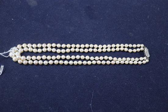 A double strand graduated cultured pearl necklace, with diamond set white metal clasp, 38cm.